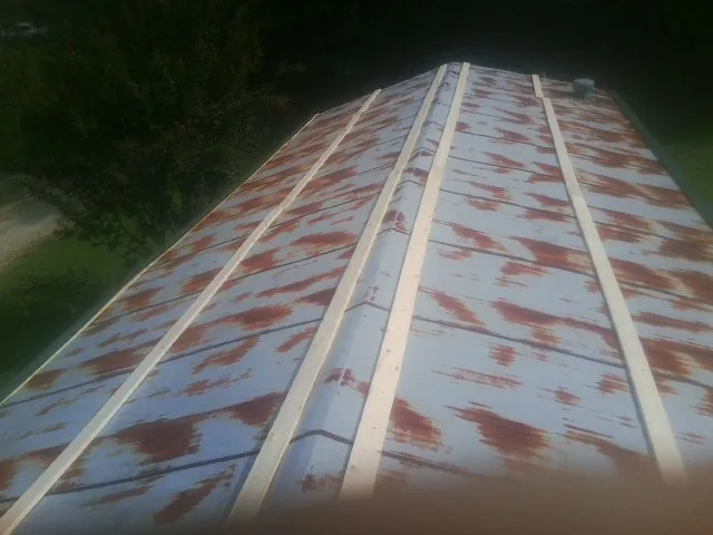 Rusted metal roof panels with new wood purlins before replacement — Storm Damage Roof Repair in Davilla by Roofing Brothers