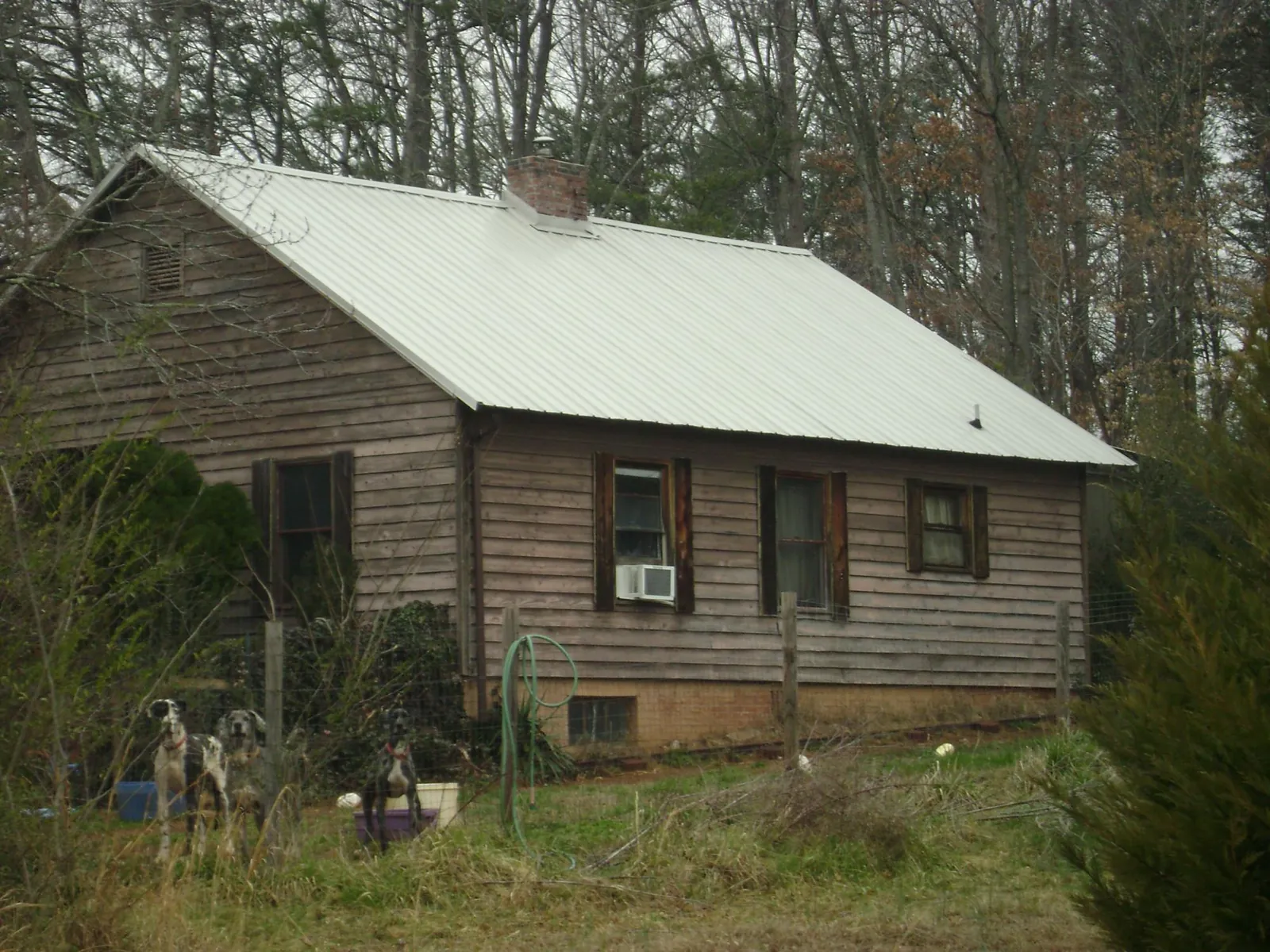 White metal roof on an old wood sided farmhouse, from a Metal Roof Installation job in Davilla